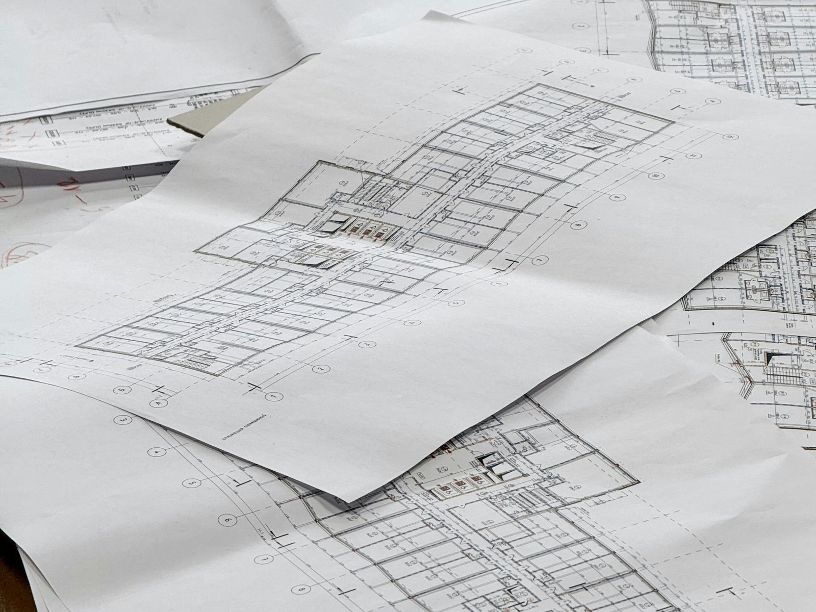 Construction floor plans spread across an architect's desk